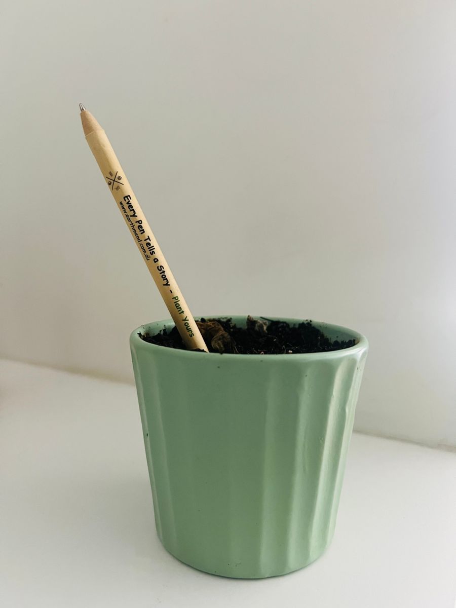 The EarthMend pen planted in a pot of soil