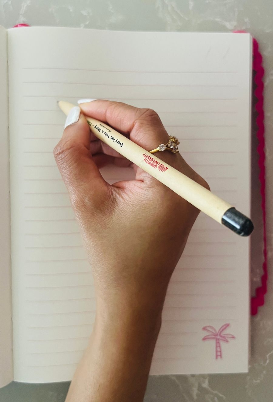 A hand writing with the EarthMend pen in a notebook